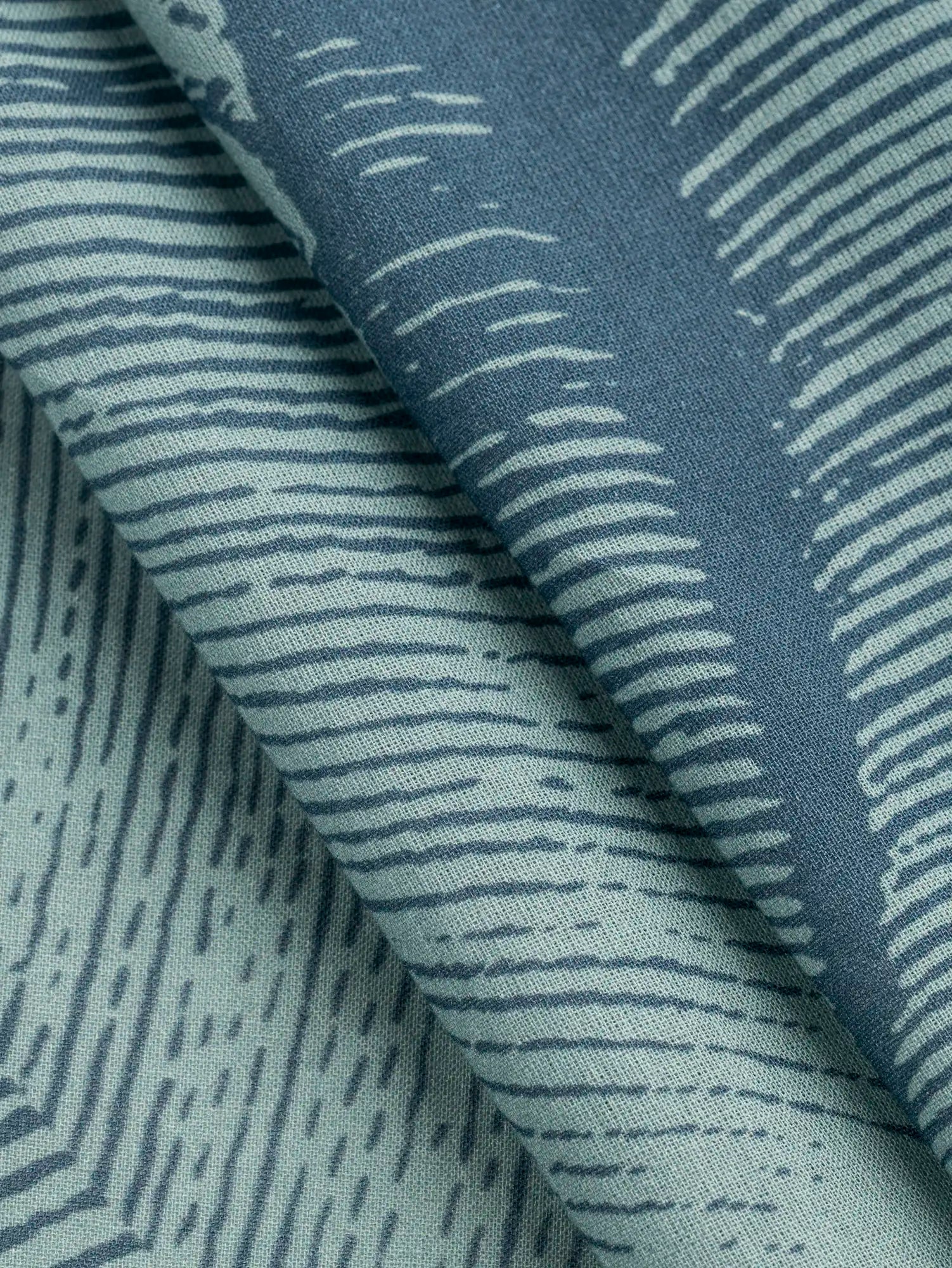 F-COT447-Abstract-Wave-Print-BCI-Cotton-Voile-Denim-and-Teal-Core-Fabrics-fold.webp