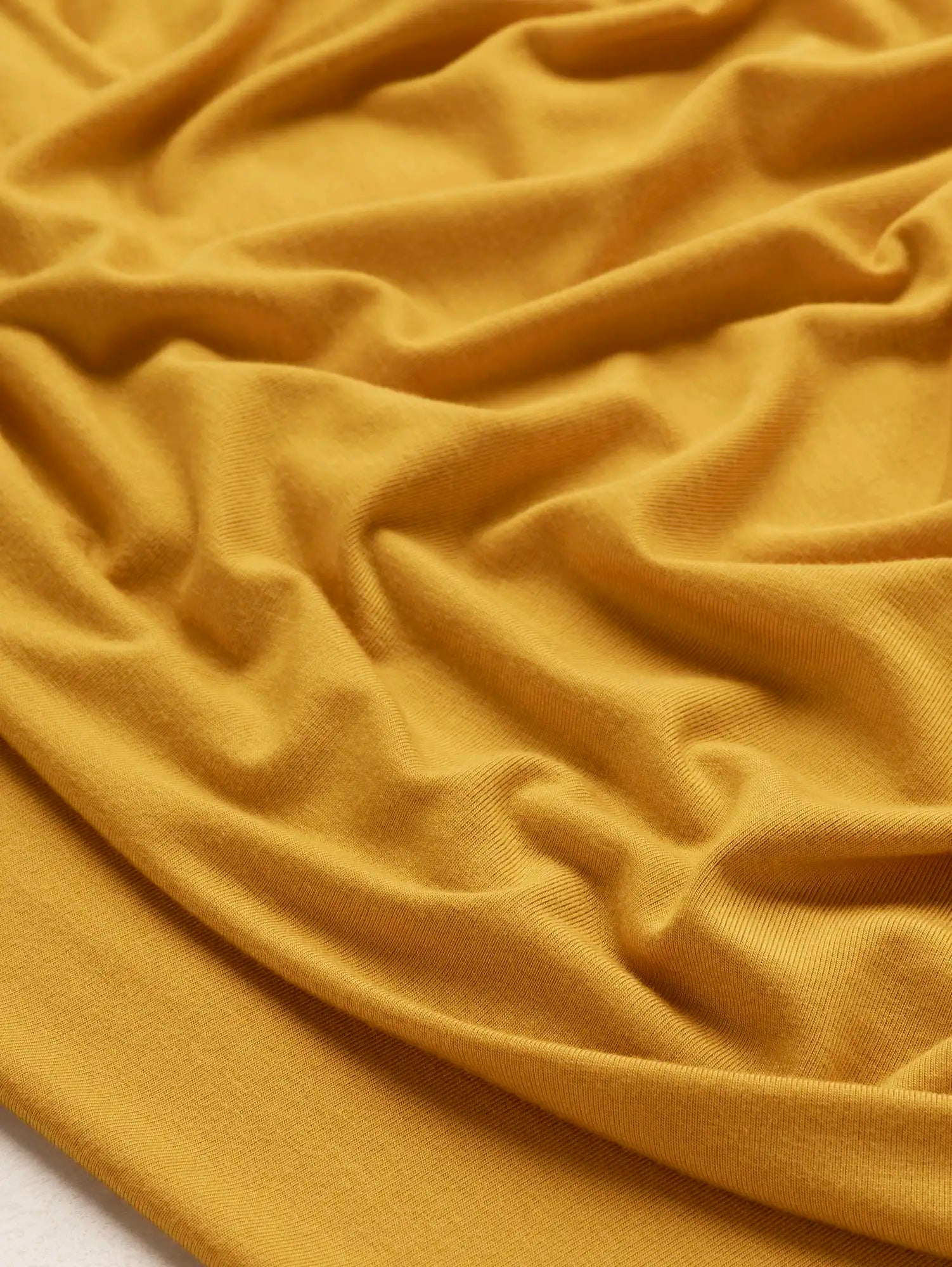 F-DEA239-Bamboo-Rayon-Spandex-Stretch-Knit-Deadstock-Mustard-Core-Fabrics-scrunched.webp