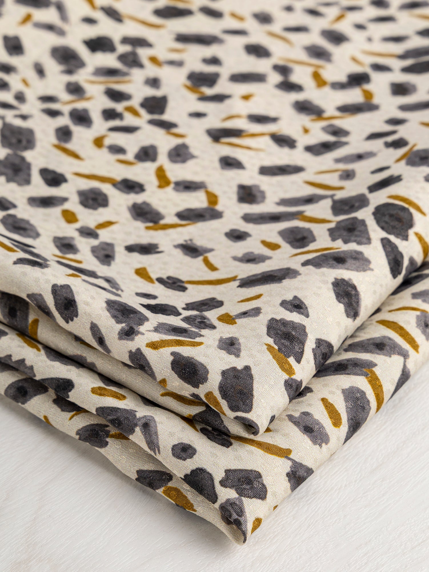 F-DEA029-Brush-Print-Viscose-Dobby-Deadstock-Cream-Steel-and-Ochre-Core-Fabrics-fold.JPG