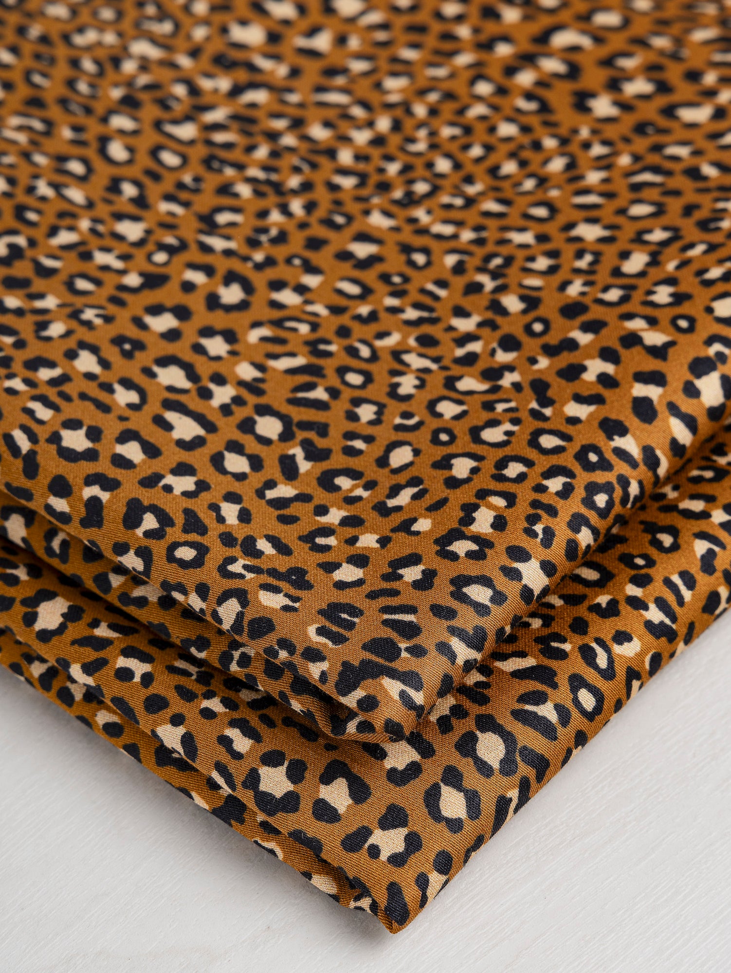 F-COT328-Ditzy-Leopard-Print-Cotton-Lawn-Ochre-Black-Beige-Core-Fabrics-fold