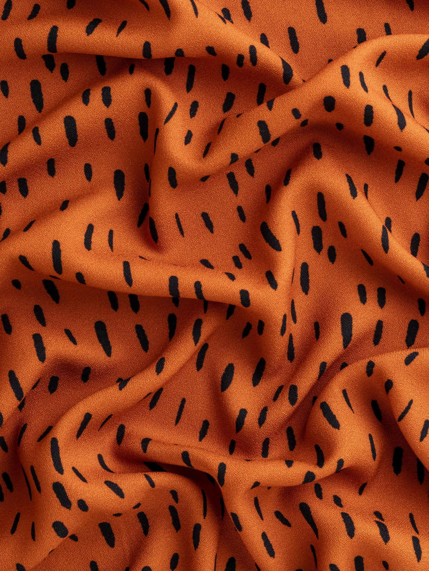 F-VIS257-Drop-Print-Viscose-Crepe-Terracotta-Black-Core-Fabrics-scrunched.JPG
