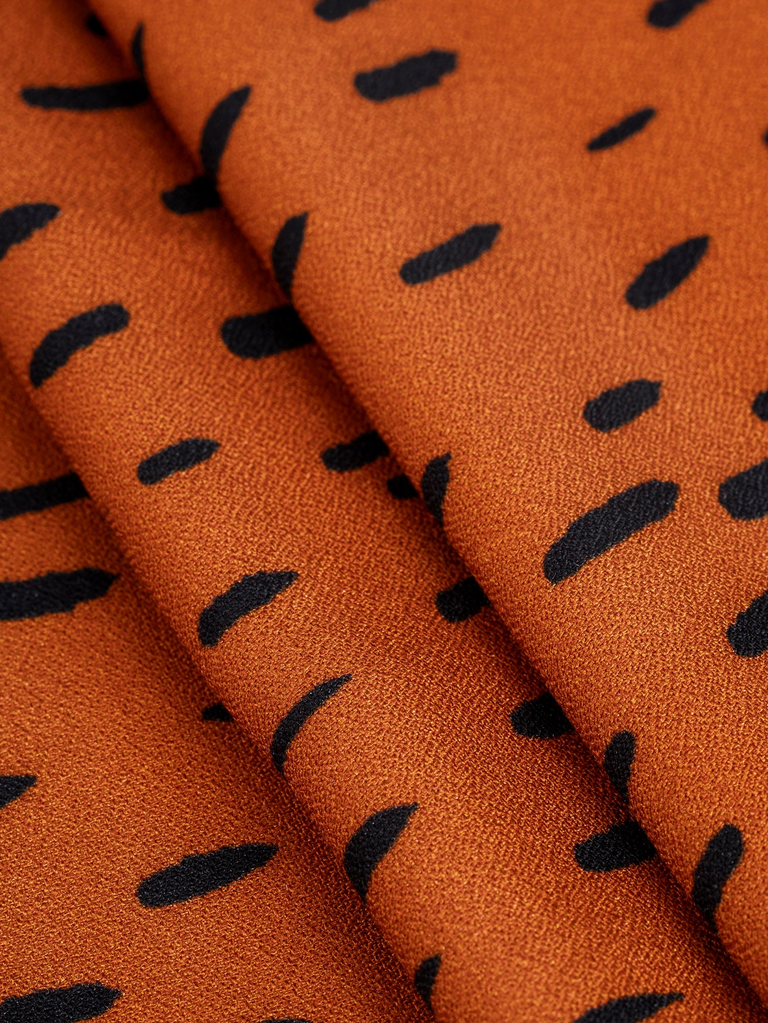 F-VIS257-Drop-Print-Viscose-Crepe-Terracotta-Black-Core-Fabrics-fold.JPG