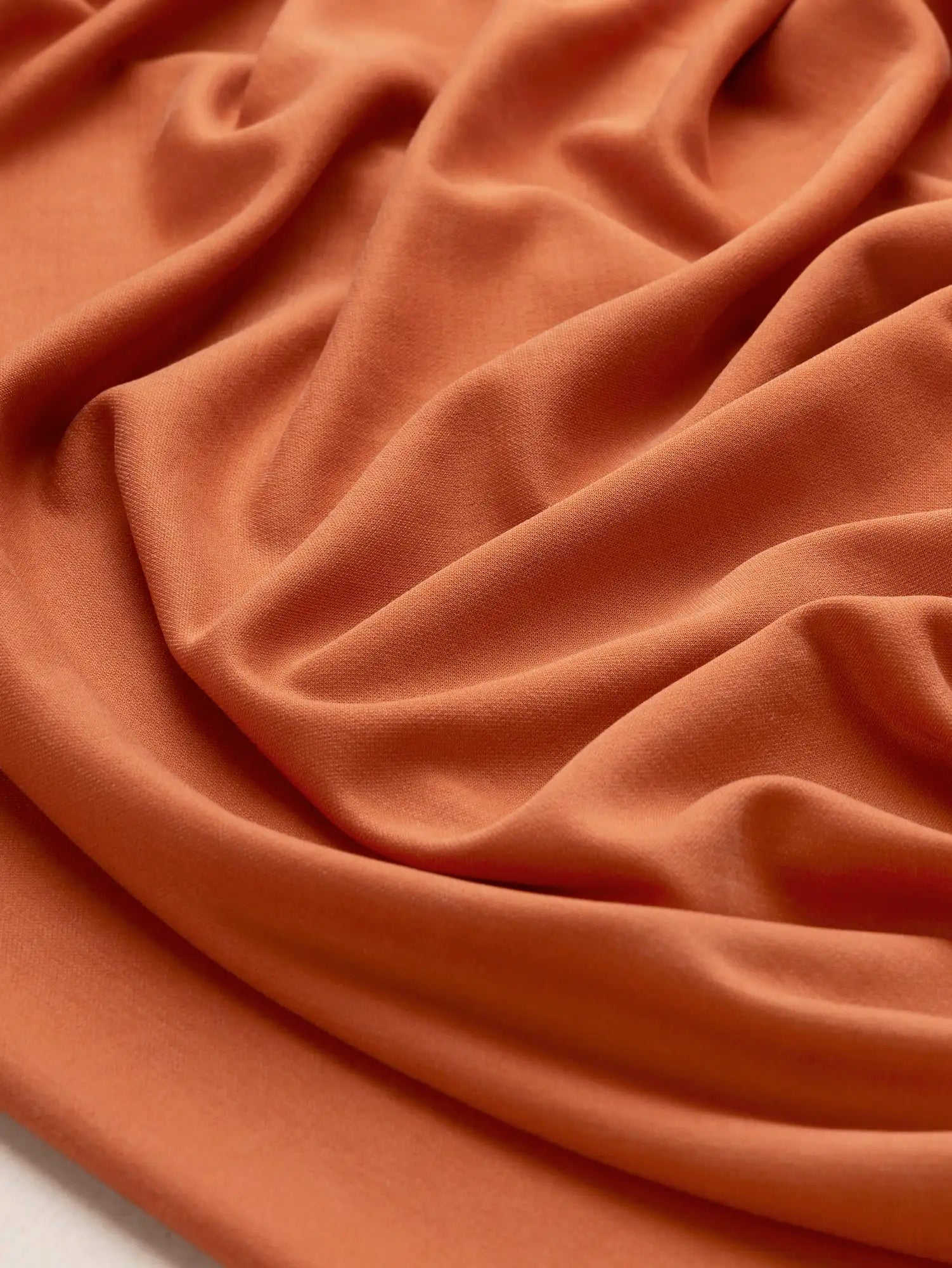 F-DEA233-Fluid-Cotton-Poly-Stretch-Knit-Deadstock-Terracotta-Core-Fabrics-scrunched.webp