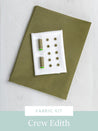 Fabric kit with spools of thread and buttons on a green fabric cover, branded 'Crew Edith'.