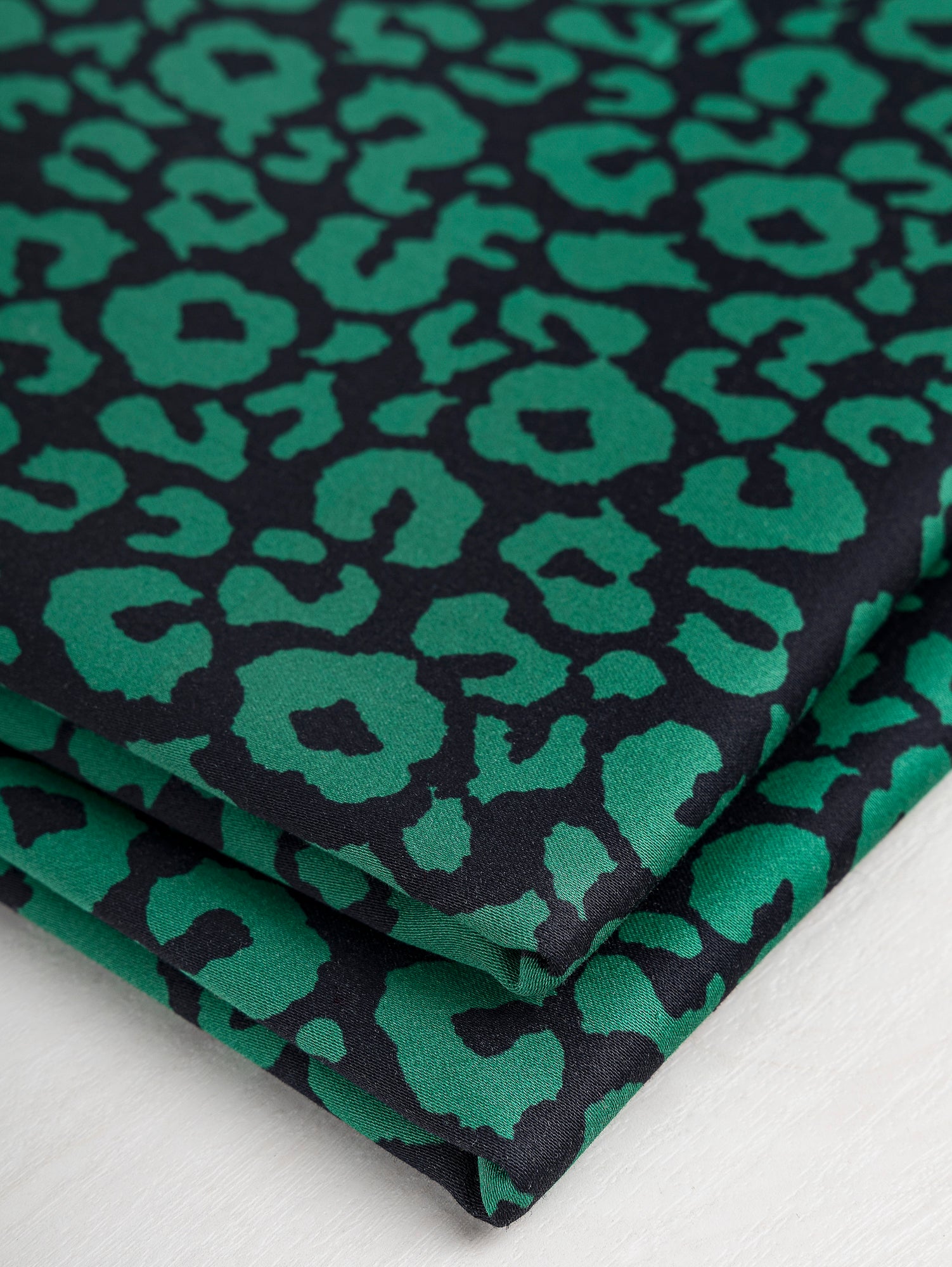 F-COT327-Leopard-Print-Stretch-Cotton-Bottomweight-Black-Green-Core-Fabrics-fold