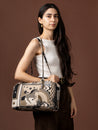 Woman holding a patterned handbag against a brown background