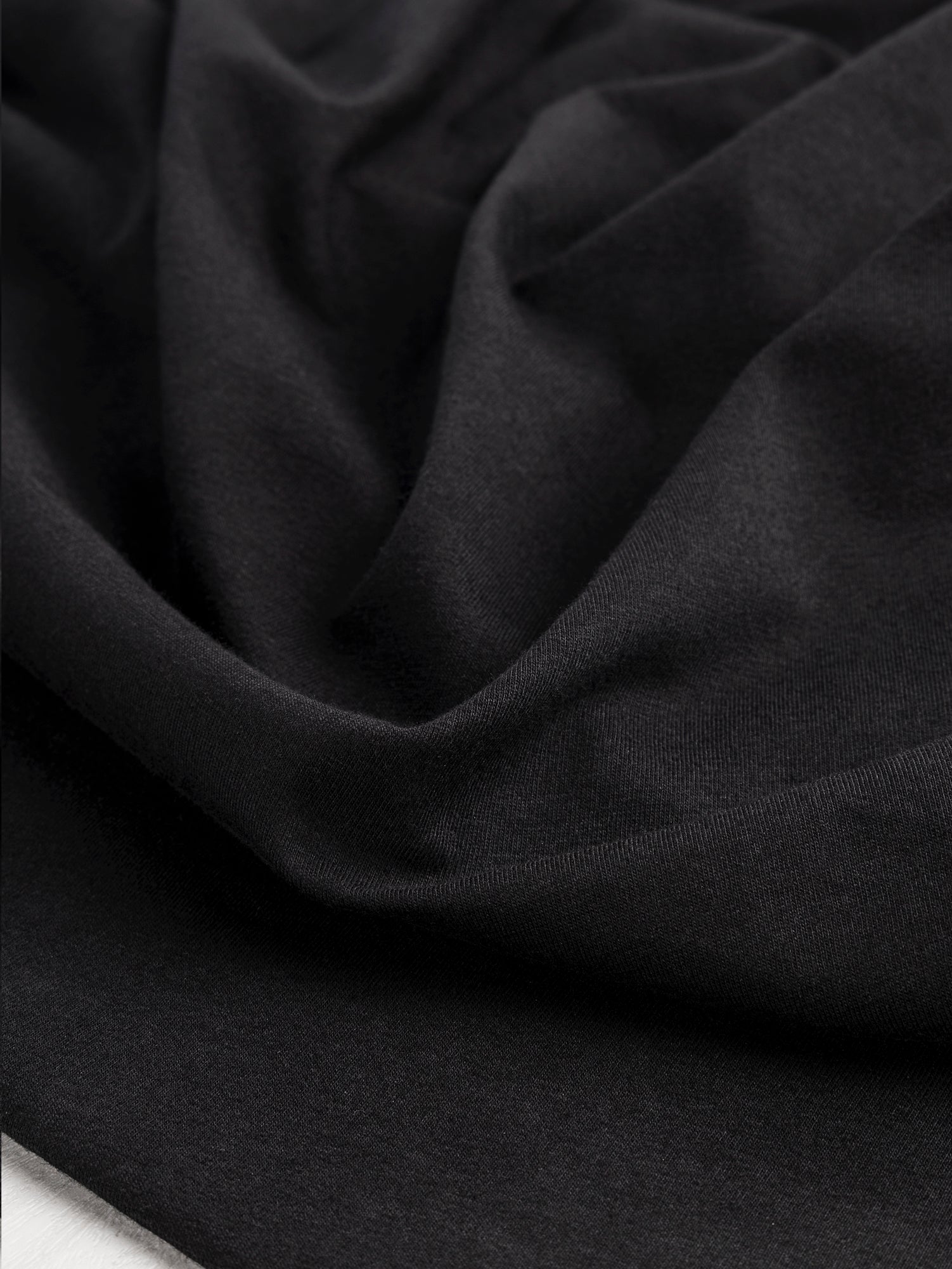 F-DEA085-002-Midweight-Organic-Cotton-Spandex-Jersey-Knit-Deadstock-Black-Core-Fabrics-scrunched.JPG