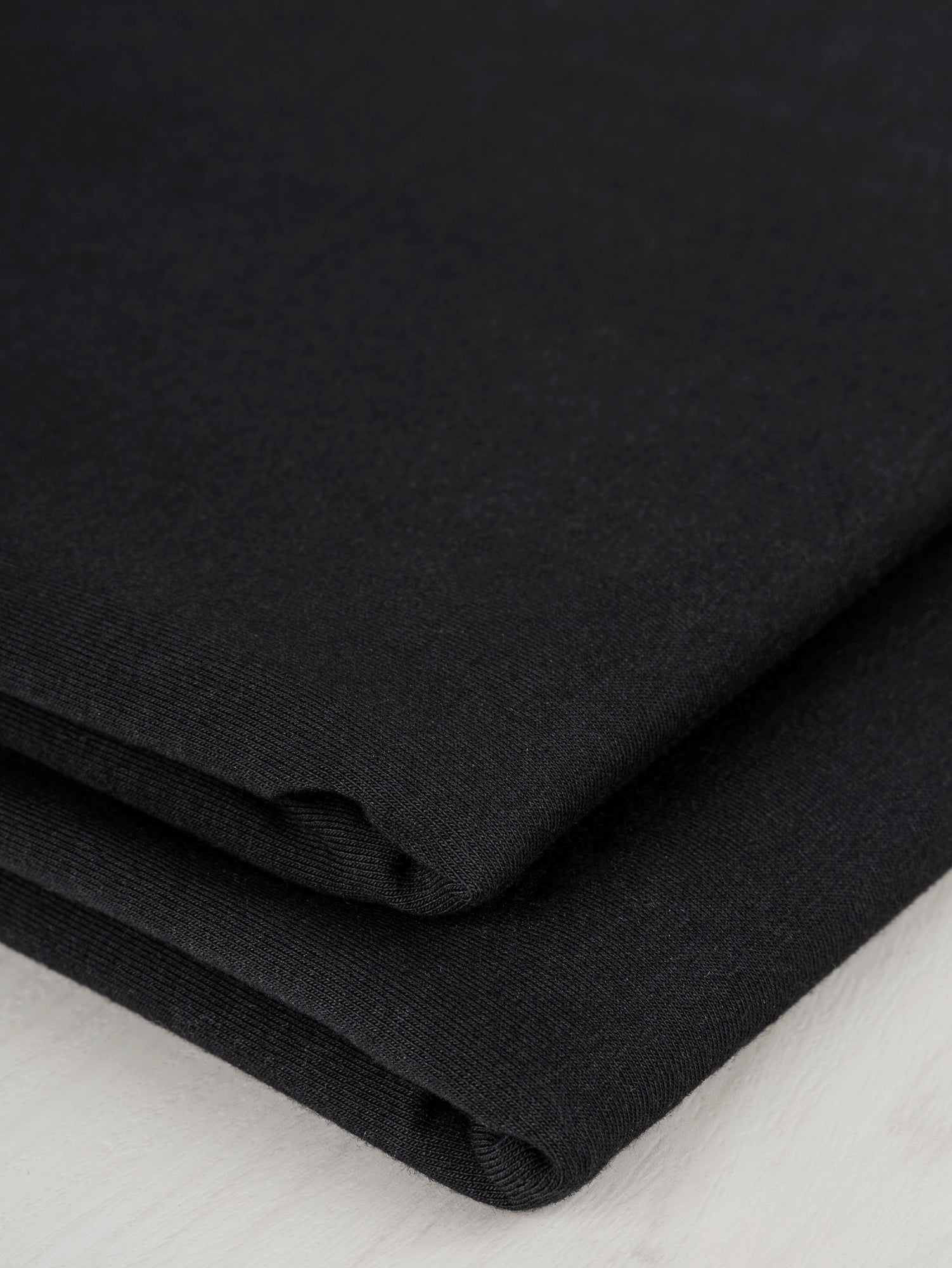 F-COT363-001-Organic-Cotton-Spandex-Jersey-Knit-Black-Core-Fabrics-fold.JPG