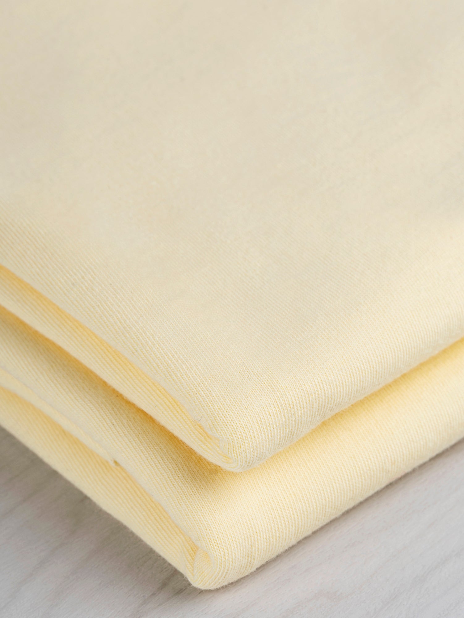 F-COT361-015-Organic-Cotton-Washed-Jersey-Knit-Butter-Yellow-Core-Fabrics-fold.JPG