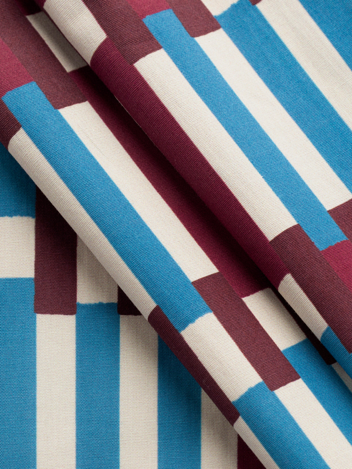 F-COT480-Piano-Print-BCI-Cotton-Poplin-Bordeaux-Cerulean-and-Ivory-Core-Fabrics-fold.webp
