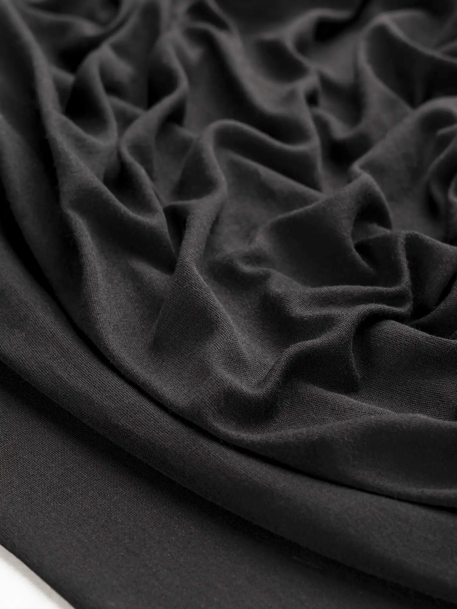 F-DEA203-001-Semi-Sheer-Viscose-Stretch-Knit-Deadstock-Black-Core-Fabrics-scrunched.webp