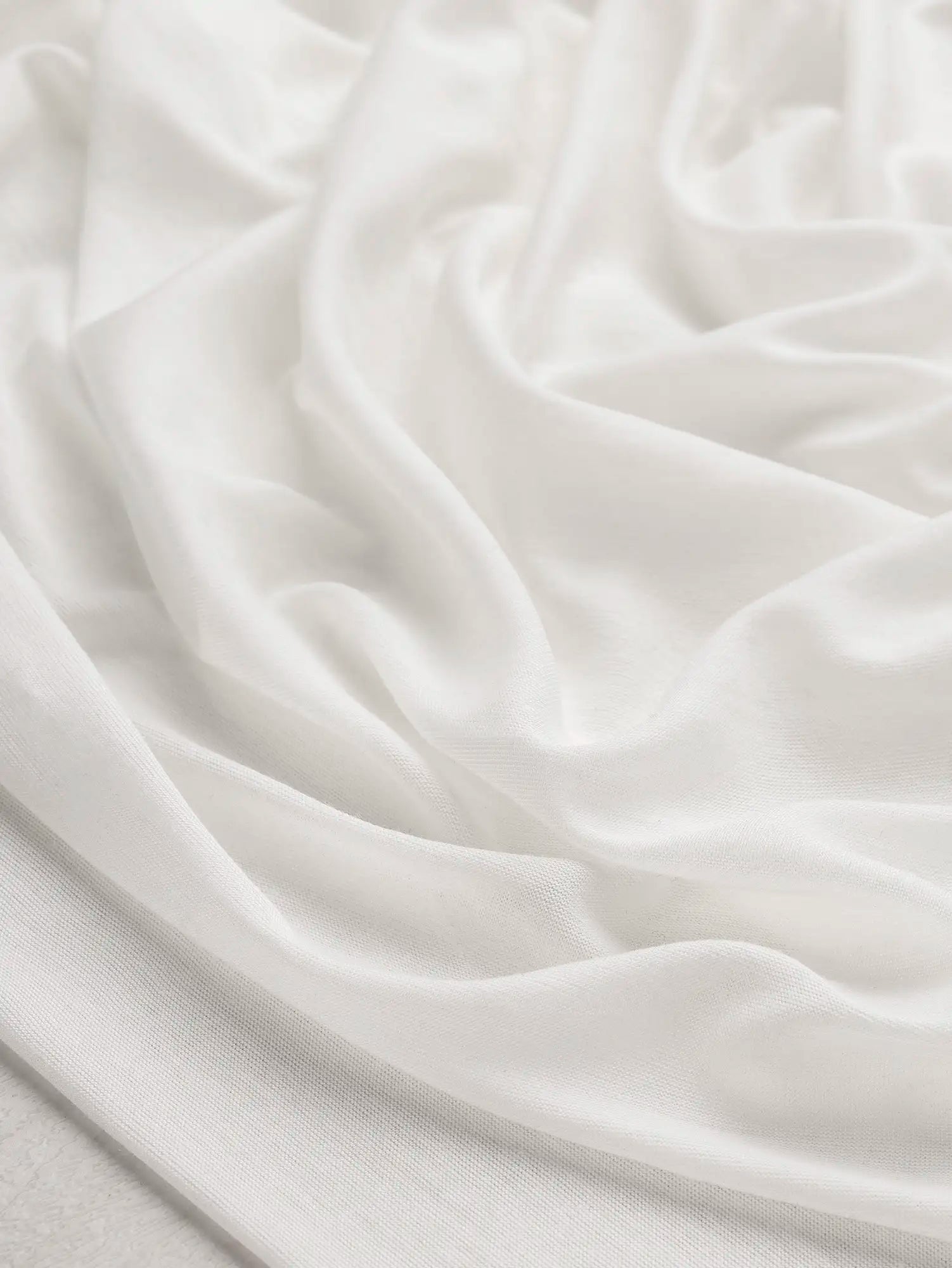 F-DEA203-002-Semi-Sheer-Viscose-Stretch-Knit-Deadstock-White-Core-Fabrics-scrunched.webp