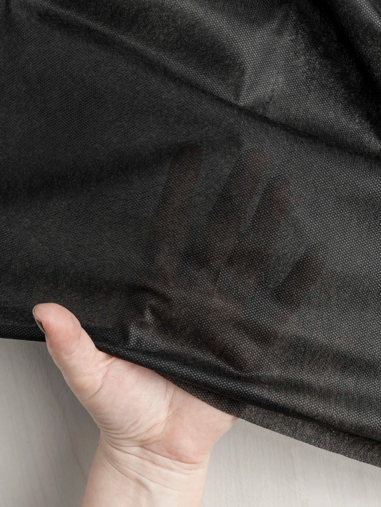 N-INT015-001-Ultra-Light-Non-Woven-Sew-On-Interfacing-Black-Core-Fabrics-Transparency.webp
