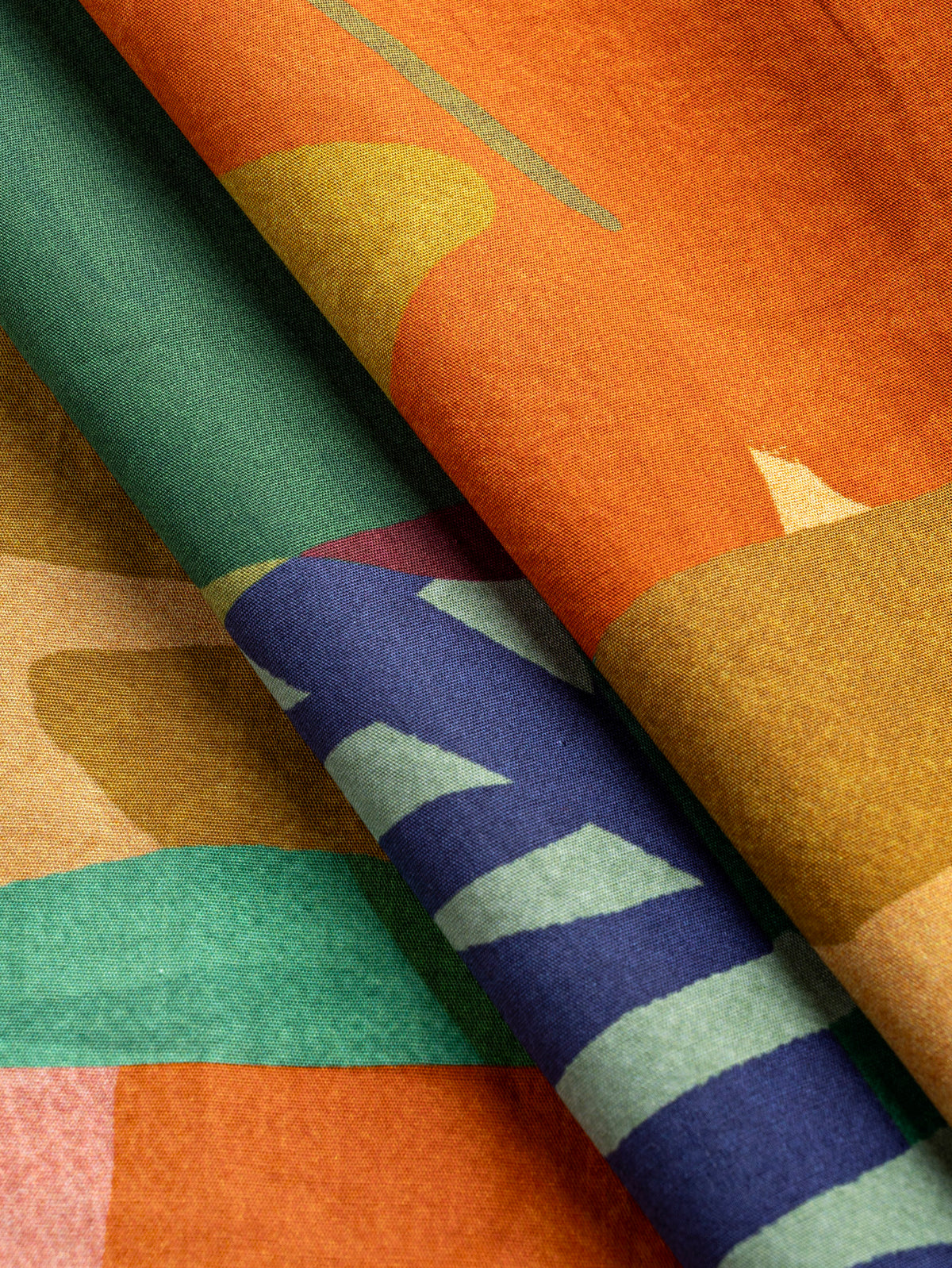 F-COT481-Vibrant-Leaf-Print-BCI-Cotton-Poplin-Magenta-Orange-and-Leaf-Core-Fabrics-fold.webp
