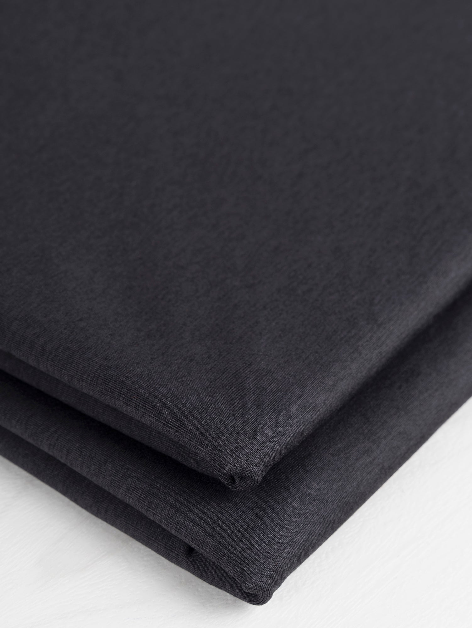 F-PES033-002-rPet-Poly-Performance-Stretch-Knit-Deadstock-Heather-Black-Core-Fabrics-fold.JPG