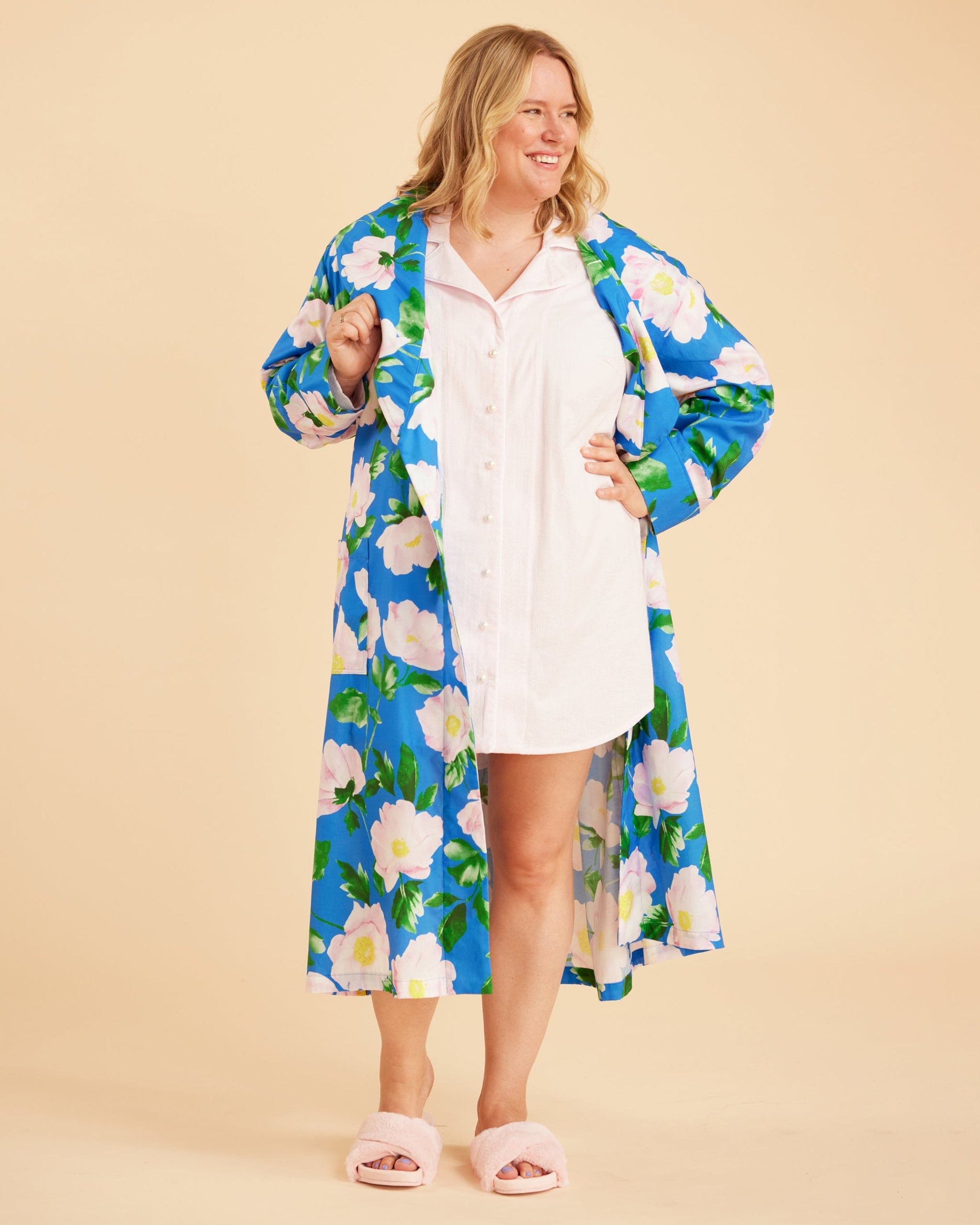 Woman wearing a blue floral robe over a white dress on a beige background. This is the Fiske Sleepwear Set sewing pattern from Cashmerette.
