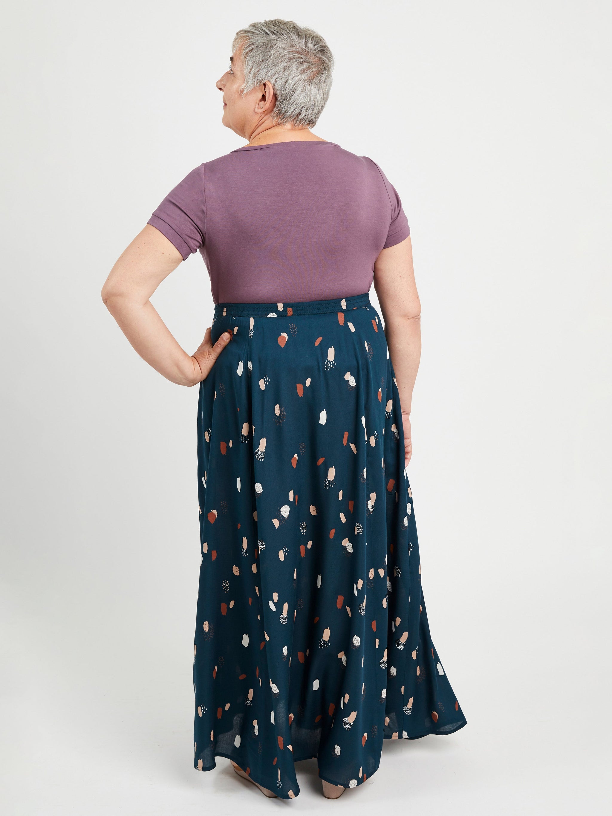 Woman wearing a purple top and blue patterned skirt on a white background. This is the Holyoke Maxi Dress & Skirt sewing pattern from Cashmerette.