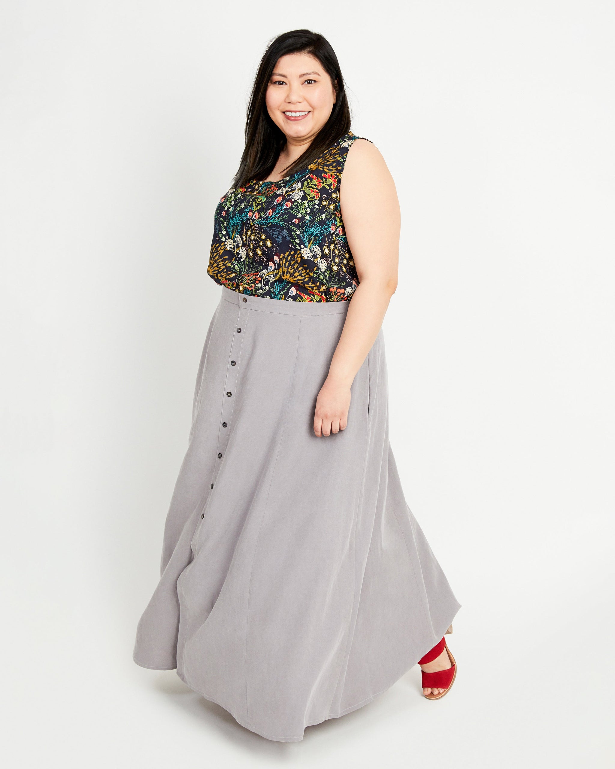 Woman wearing a floral top and gray skirt on a white background. This is the Holyoke Maxi Dress & Skirt sewing pattern from Cashmerette.